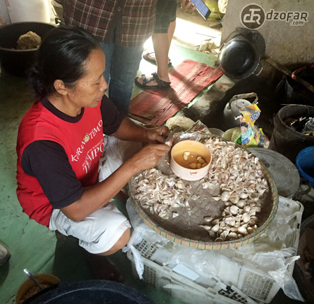 Ibu Daryati mengupas bawang